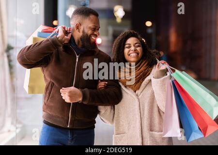 Portrait of happy afro couple walking with shopping bags Stock Photo