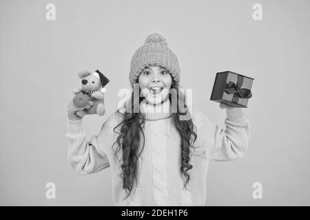 Taking two. child knitted clothes with toy rat. toy shop for kids. christmas is here. xmas winter holiday. happy new 2020 year. cute santa mice toy gift. small girl hold mouse toy and present box. Stock Photo