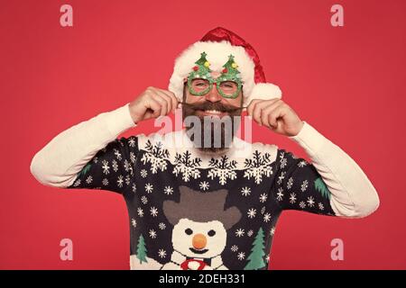 Fashion design for keeping festive. Fashion santa red background. Happy man twirl fashion mustache. Stylish trends for holiday celebration. Merry Christmas. New year, new fashion. Stock Photo