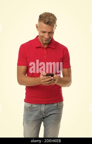 Texting SMS. Happy man send sms via smartphone isolated on white. Sms messaging. Short message service. SMS delivery confirmation. Mobile lifestyle. Modern life. Stock Photo