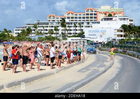 Maho Beach packed with tourists waiting departing aircraft from St. Maarten Airport in the Caribbean awating jet blast. Popular SXM tourist activity. Stock Photo