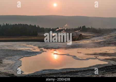 Heart Spring with the Castle Geyser in the distance near sunset in the Upper Geyser Basin of Yellowstone National Park, Wyoming, USA. Stock Photo