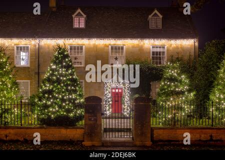 Festive winter tree decorations with large silky poinsettia flowers,  glitter tree balls and golden mesh ribbons, seasonal Christmas ornamentas  Stock Photo - Alamy