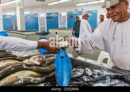 Middle East, Arabian Peninsula, Oman, Muscat, Muttrah. Oct. 21, 2019. Vendor selling fish at the souk in Muttrah. Stock Photo