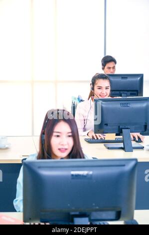 Young customer service women agent with headsets and computer working at office. Professional operator concept. Stock Photo