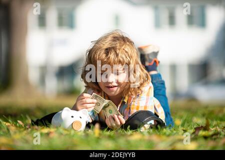 Cute little boy holding money. Child saving with one coin. Money building strategy. Portrait kid with piggy bank and coin. Getting started saving