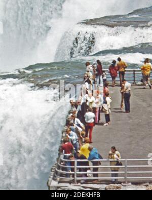 1970s Photo (1973) -  From the lookout point on Luna Island; visitors on the American side view the spectacular plunge of the waters at the brink of Niagara Falls Stock Photo