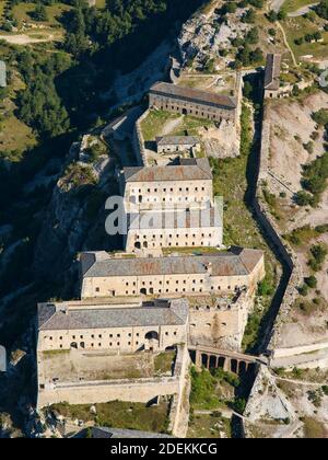 AERIAL VIEW. Military barracks on a steep limestone ridge above the Arc Valley. Victor-Emmanuel Fort, Aussois, Savoie, Auvergne-Rhône-Alpes, France. Stock Photo