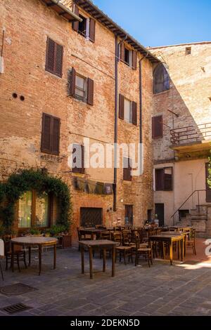 Buonconvento, Italy - September 3rd 2020. A outdoor restaurant bar in the centre of historic medieval village of Buonconvento in Siena Province, Tusca Stock Photo