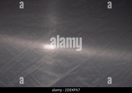 Texture of gray fabric with a beam of flashlight light, gray background. Stock Photo