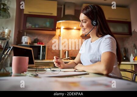 Nice person talking through a headset and writing the results Stock Photo