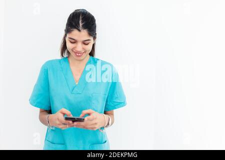 Nurse using smartphone standing in the clinic with withe background Stock Photo