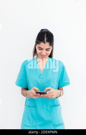 Nurse using smartphone standing in the clinic with withe background Stock Photo