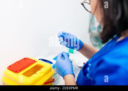 Female doctor preparing syringe with injection