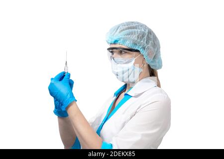 nurse in a protective mask and glasses and gloves, holds a syringe with medicine, isolated background. Medicine and health. Fighting Coronavirus. Stock Photo