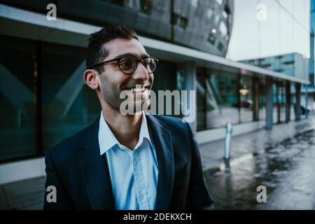 Mixed race businessman smiling walking to work before conference meeting  Stock Photo