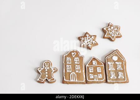 Decorative Christmas food composition. Winter composition of star shaped gingerbread cookies with sugar icing isolated on white table background. Flat Stock Photo