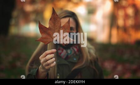 Young woman holding a dry leaf Stock Photo