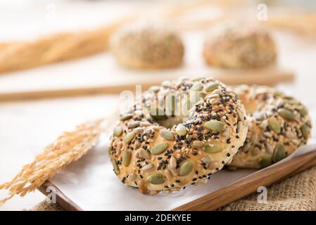 A healthy oven baked multigrain doughnut buns served on a wooden plate in a bakery Stock Photo