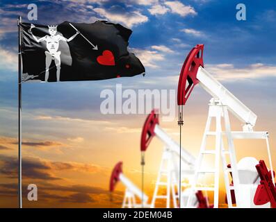 Oil rigs against the backdrop of the colorful sky and a flagpole with the flag of Blackbeard Pirate. The concept of oil production, minerals, developm Stock Photo