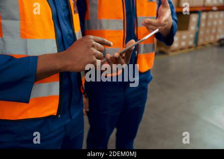 Mid section of two male employees holding digital tablet in manufacturing industry Stock Photo