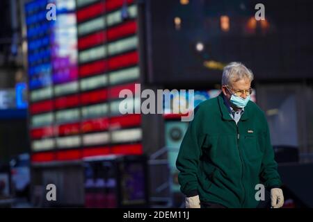 Washington, USA. 18th Nov, 2020. A man wearing a face mask walks at the Times Square in New York, the United States, Nov. 18, 2020. TO GO WITH XINHUA HEADLINES OF DEC. 1, 2020 Credit: Wang Ying/Xinhua/Alamy Live News Stock Photo