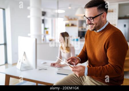Handsome businessman using tablet in office. Technology, business, people concept. Stock Photo