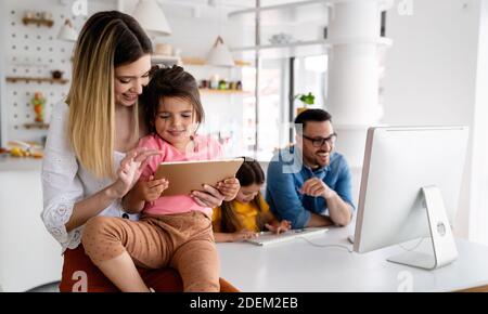 Business parents interrupts by her children while working in home office Stock Photo