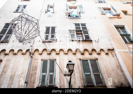 The facade of apartments in the old quarter of the city of Nice South of France. Showing shutters and washing lines and traditional architecture. Stock Photo