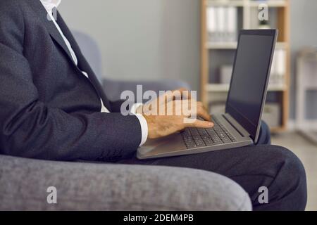 Businessman typing on laptop keyboard, entering data into database or doing marketing research Stock Photo