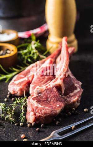 Slices raw lamb chops on black table. Stock Photo