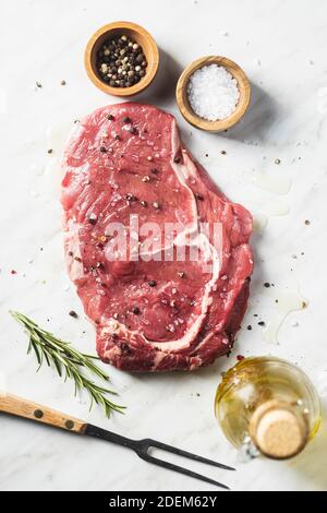 Sliced raw ribeye steak on a white kitchen table. Top view. Stock Photo