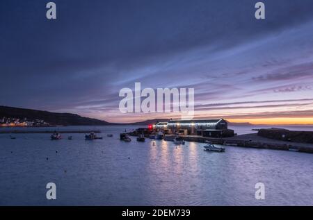 Lyme Regis, Dorset, UK. 1st Dec, 2020. UK Weather: Beautiful dawn colours over historic Cobb as December gets off to a cold and wintery start. The Chrismas lights along the Cobb sparkle brightly as the Christmas season gets underway. Credit: Celia McMahon/Alamy Live News Stock Photo