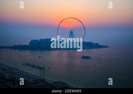 Evening sunset view of Dubai eye ferris wheel with sun inside and six installed cabins Stock Photo