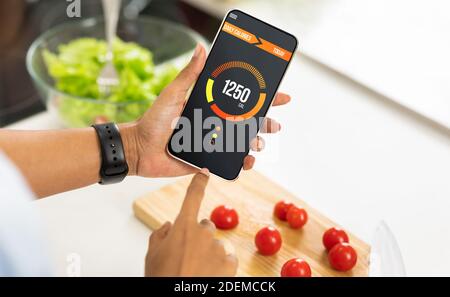 Weightloss Concept. Woman Holding Smartphone With Opened App For Counting Daily Calories Stock Photo