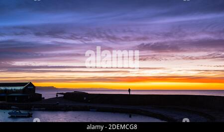 Lyme Regis, Dorset, UK. 1st December 2020. UK Weather: Beautiful dawn colours over historic Cobb as  December gets off to a cold and wintery start. A photographer captures the beautiful scene. Credit: Celia McMahon/Alamy Live News. Stock Photo