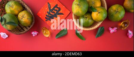 Top view of fresh ripe tangerine mandarin orange with fresh leaves on red table background for Chinese lunar new year fruit concept, the Chinese word Stock Photo