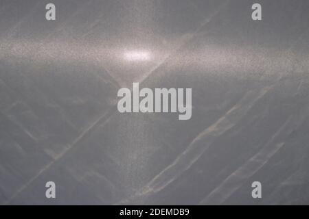 Texture of gray fabric with a beam of flashlight light, gray background. Wrinkled cloth Stock Photo