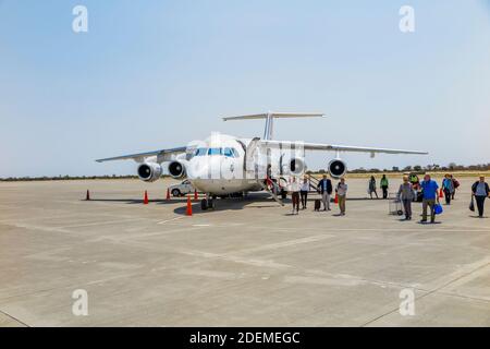 Passengers disembarking from a South African Airlink Avro RJ85 on the runway on arrival on a regional flight, Maun Airport, Botswana, southern Africa Stock Photo