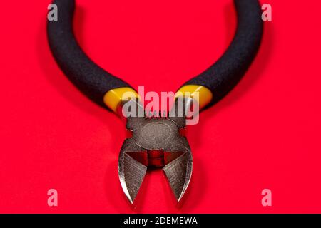 Nippers on a red background tool for cutting wires, cables and wire, for the electrician. The needle nose pliers Stock Photo