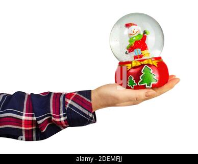 Isolated photo of a girl hand in shirt holding christmas decorative snowball toy on white background. Stock Photo