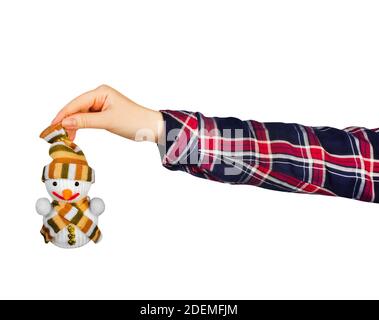 Isolated photo of a girl hand in green shirt holding snowman decorative toy on white background. Stock Photo