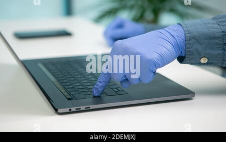 Nurse pressing the enter key on laptop. Working on a medical consultation to prevent the spread of Covid 19 or Coronavirus. Stock Photo