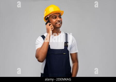 indian builder in helmet calling on smartphone Stock Photo