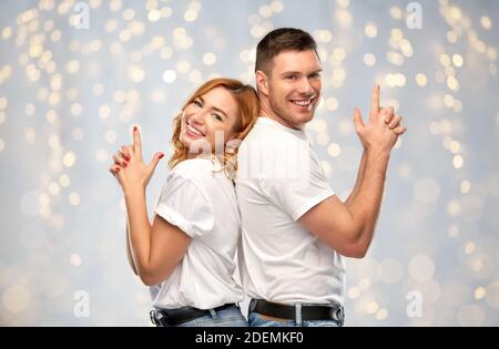 couple in white t-shirts shirts making gun gesture Stock Photo
