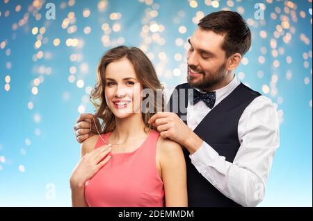 happy man puts necklace on his girlfriend Stock Photo