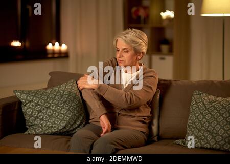 senior woman suffering from pain in hand at home Stock Photo