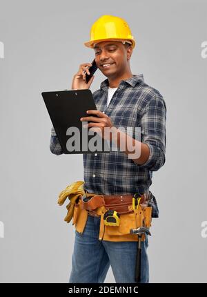 indian builder in helmet calling on smartphone Stock Photo