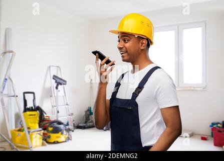 happy indian builder recording voice on smartphone Stock Photo