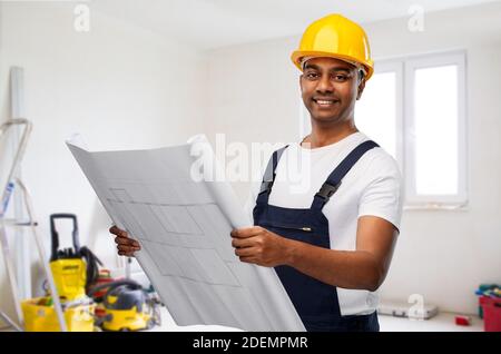 happy indian builder in helmet with blueprint Stock Photo